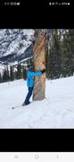 Derek in the middle of a run at Copper Mountain, hugging the dead trunk of a tree that has a lightning scar on it, and no branches.